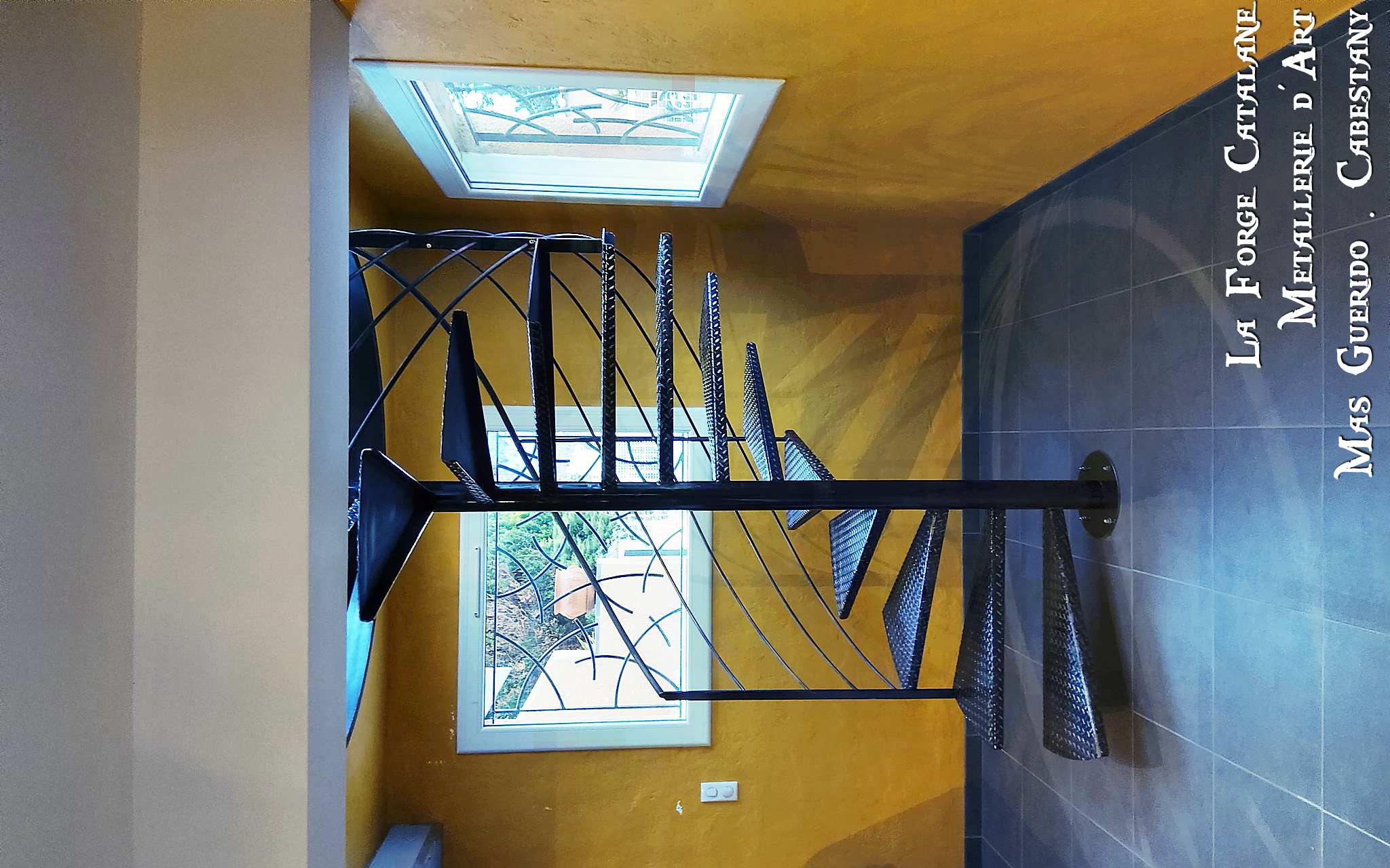 escalier colimacon en fer avec rampant peripherique et capotage de finition bord de tremie forge catalane 1.jpg